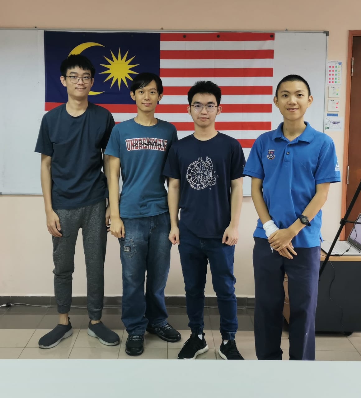 A group of men posing for a photo in front of a flag

Description automatically generated